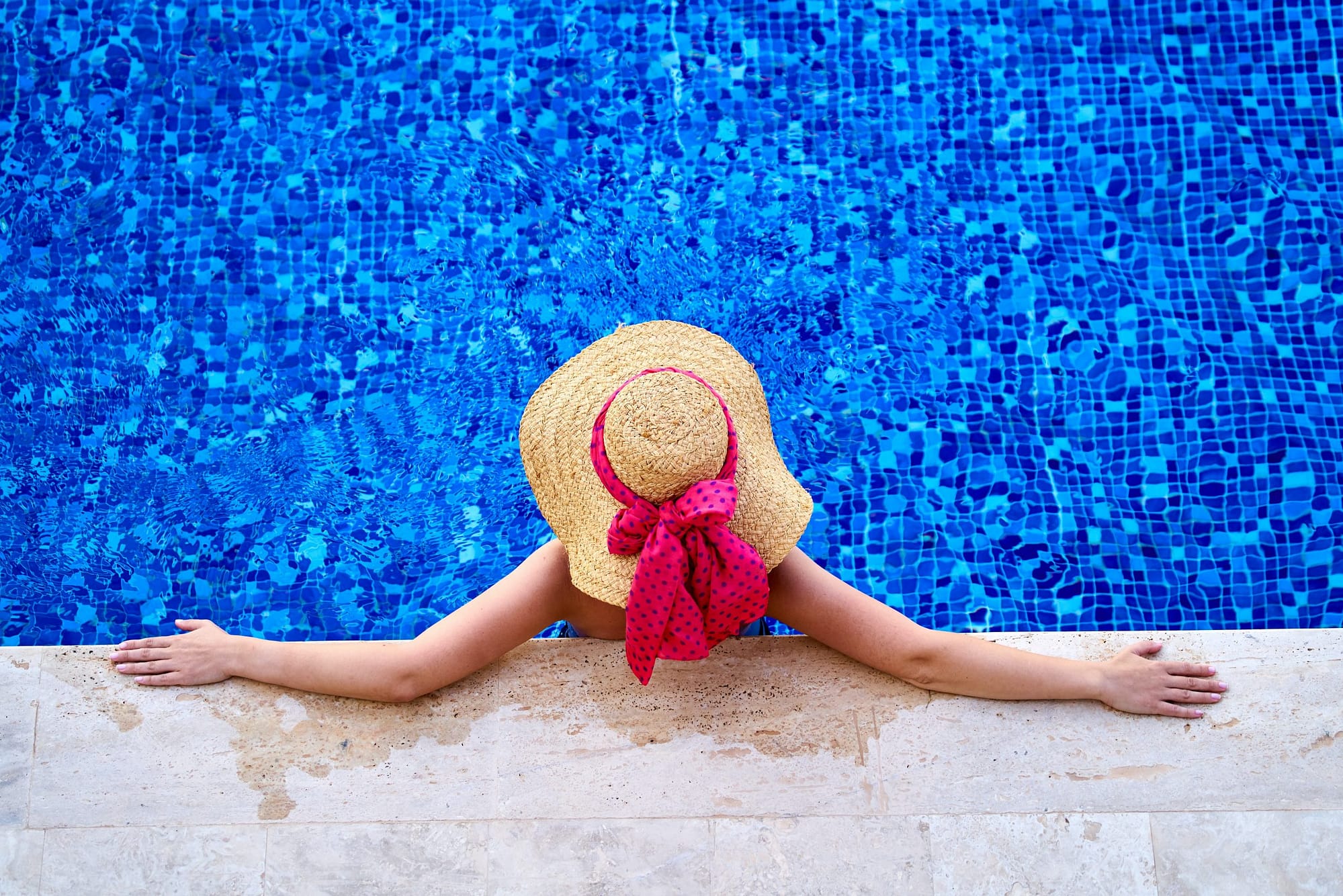 lady relaxing at the edge of the swimming pool